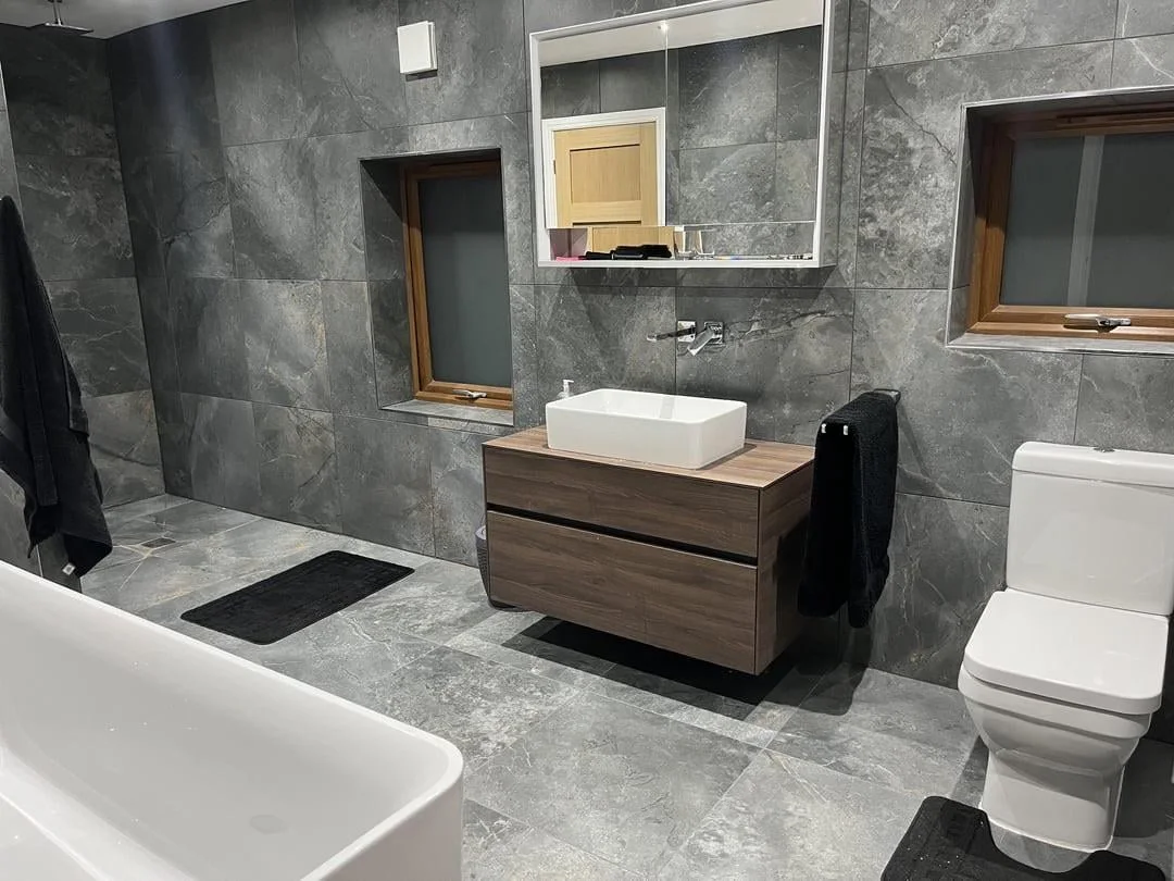 Original Reddit bathroom with dark gray tile and hard-edged finishes
