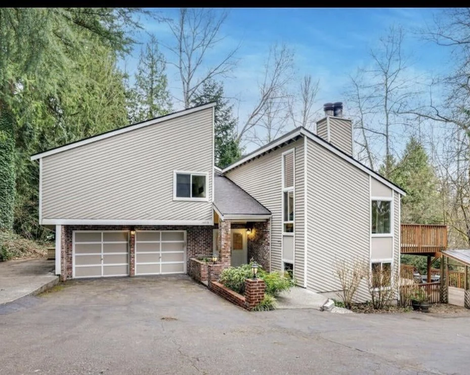 Original public Reddit photo of a light-sided house with a red-brick base and trees